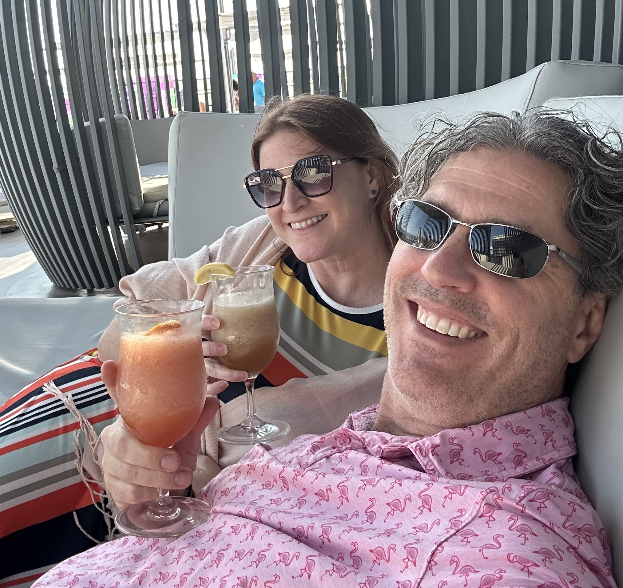 Nathan and Mandy holding drinks while enjoying Rock Star status on Virgin Voyages Scarlet Lady.